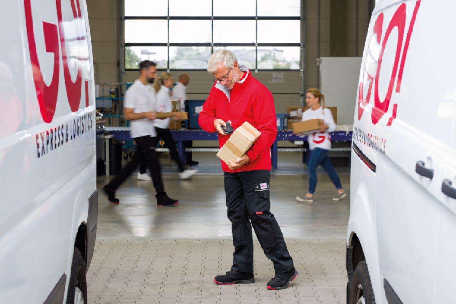 Courier scans package. Around 4,000 companies in the courier, express, and parcel industry in Germany currently generate annual revenues of 26.5 billion euros, employ more than 260,000 people, and handle approximately 4.18 billion shipments per year. (Photo: GO! Express & Logistics Deutschland GmbH)