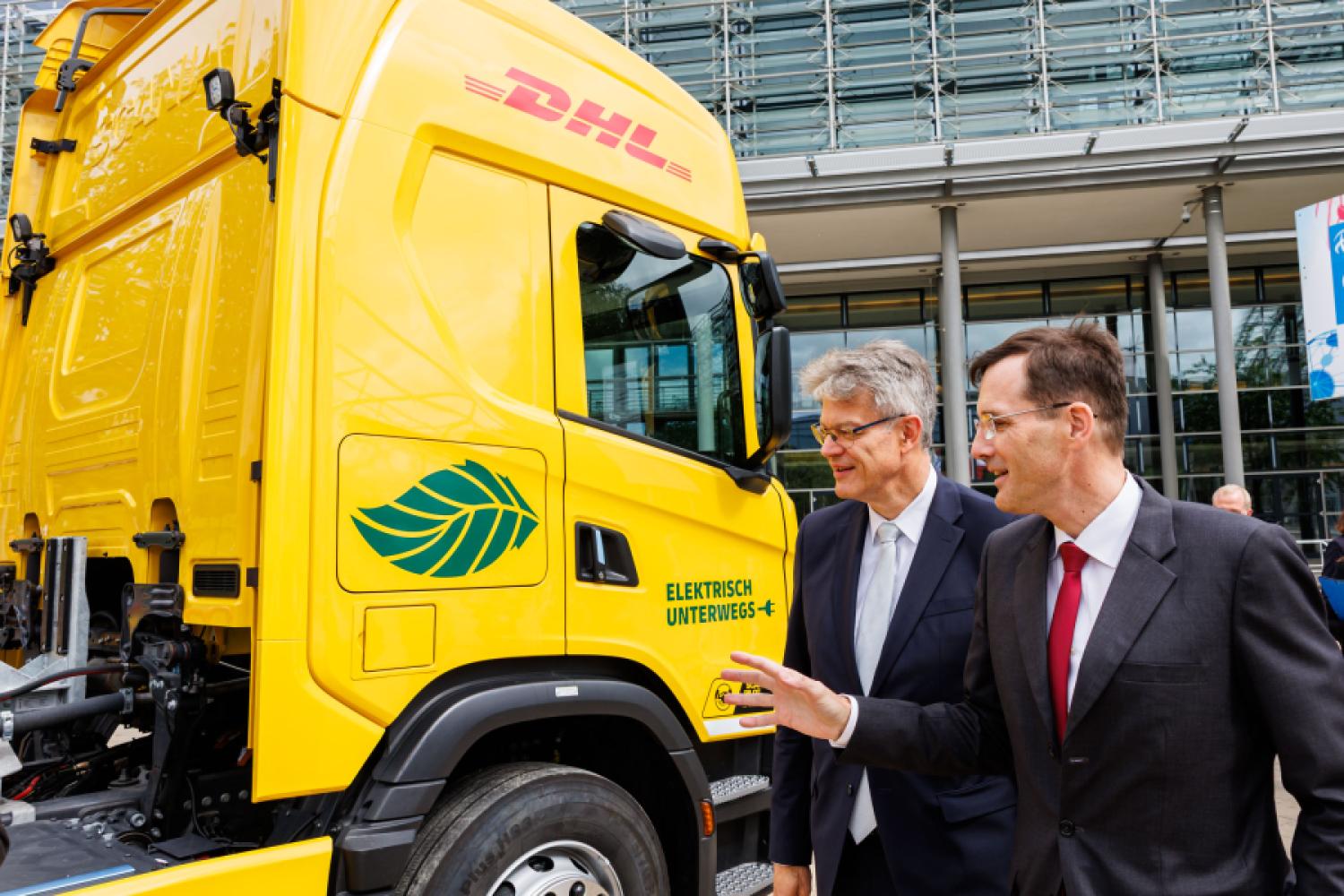 Tobias Meyer, CEO of the DHL Group, explains the battery-electric Scania truck with range extender to Federal Minister of Transport Patrick Schnieder. | Image: DHL