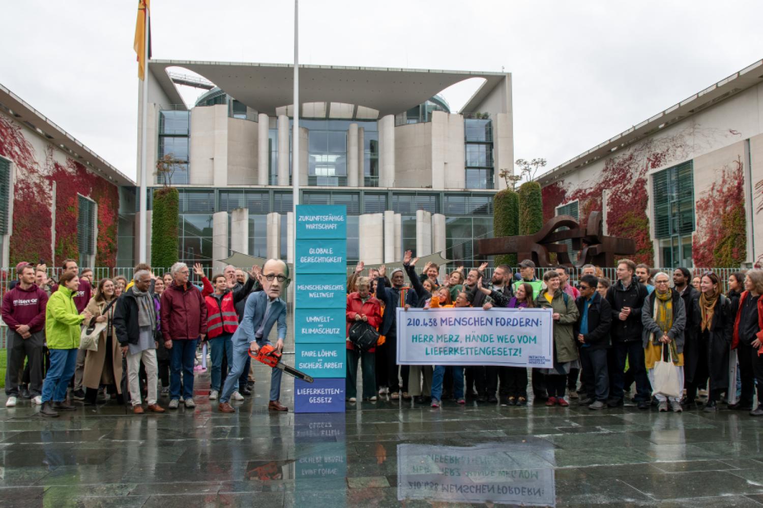 The organizers of the petition, together with a cardboard Chancellor, place emphasis on their stance in front of the Federal Chancellery. (Image: Initiative Lieferkettengesetz)