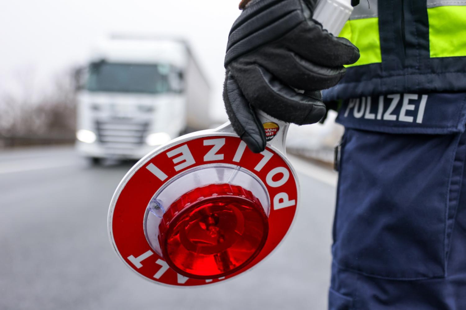 A police officer holds a signal disc for an inspection on the highway. (Photo: Jan Woitas/dpa)