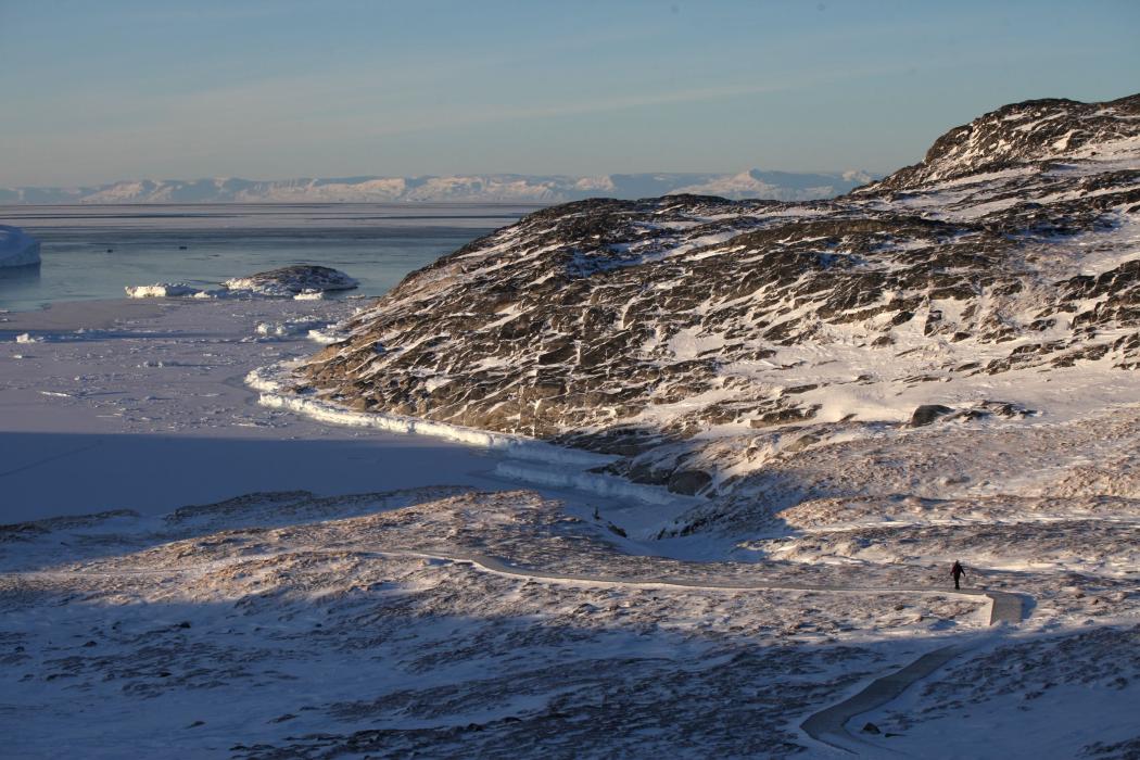 A woman walks through a snowy rocky landscape at the Ilulissat Icefjord in Greenland. Greenland's immense raw material resources have long since attracted the interest not only of US President Trump but also of the EU. (Photo: Steffen Trumpf/dpa)