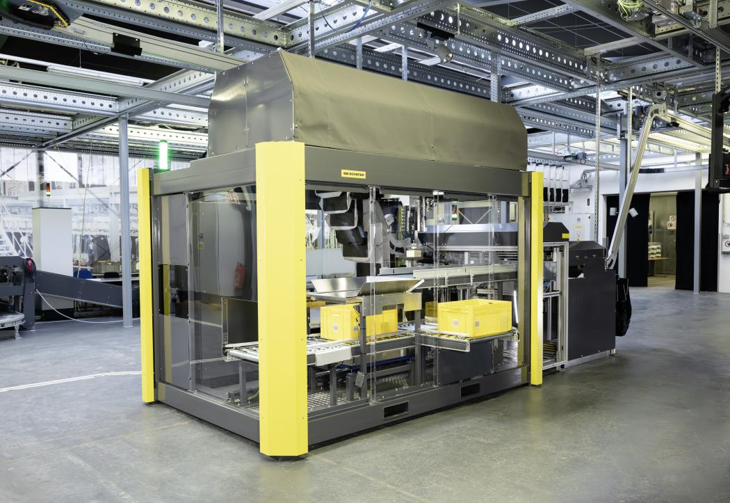 The compact design of the robotic cell and loading station, which also includes the feed to the automatic transfer station, has a positive impact on space utilization according to SSI Schäfer. (Image: SSI Schäfer)
